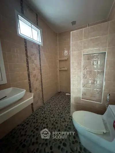 Modern bathroom with stylish pebble flooring and sleek fixtures