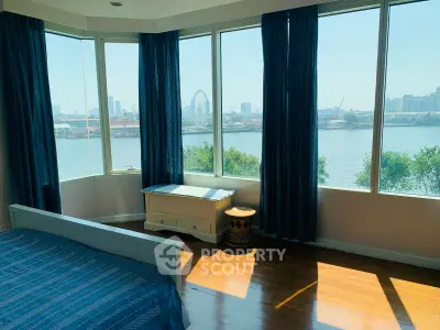 Stunning bedroom with panoramic river view and large windows.