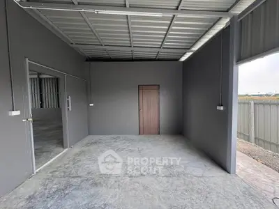 Spacious industrial-style storage unit with concrete flooring and metal roofing.