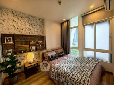 Stylish bedroom with modern decor and large windows offering city views.
