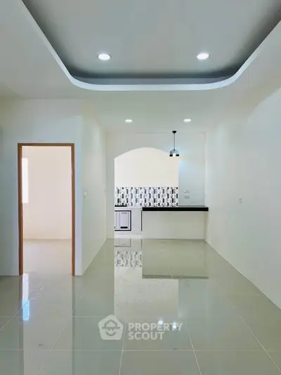 Modern open-layout kitchen with sleek design and stylish lighting in a bright apartment.