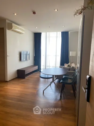 Modern living room with wooden flooring, stylish furniture, and natural light.