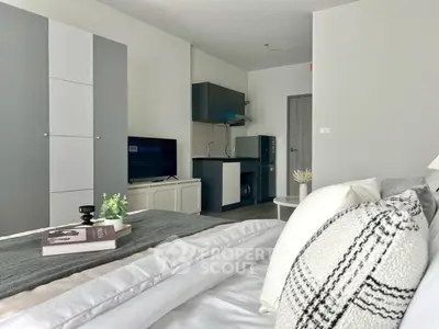 Modern studio apartment with cozy bed and compact kitchen area