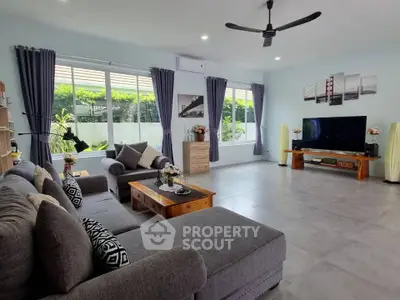Spacious living room with modern decor and large windows offering natural light.
