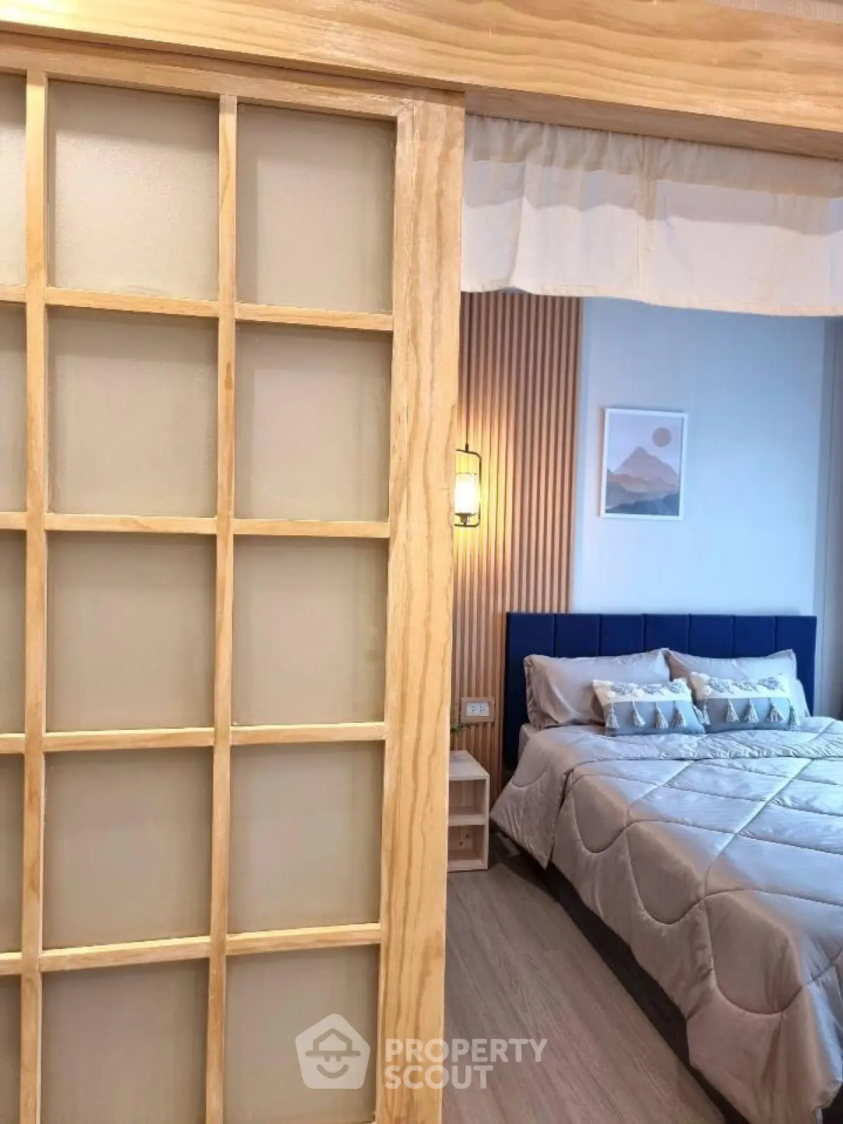 Cozy bedroom with modern decor and sliding wooden door for stylish living.