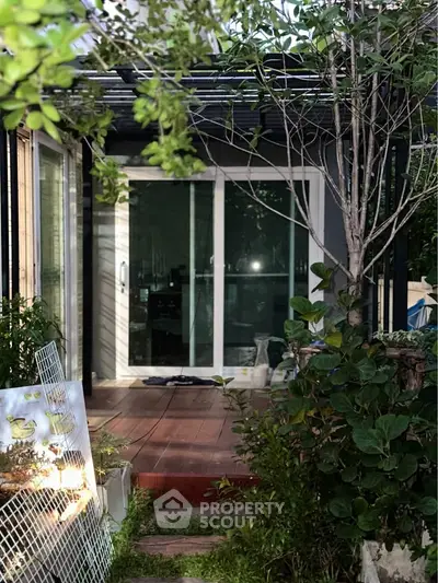 Charming garden view with sliding glass doors leading to a cozy patio, perfect for relaxation and outdoor enjoyment.