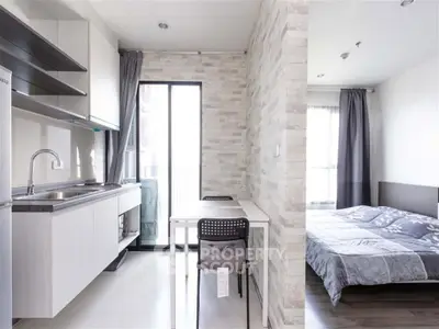 Modern studio apartment with open kitchen and cozy bedroom, featuring sleek design and natural light.