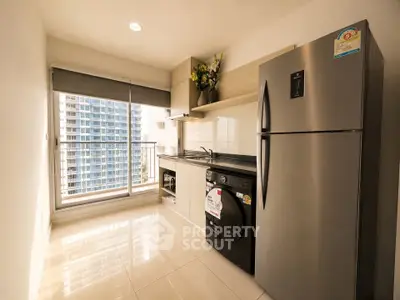 Modern kitchen with stainless steel appliances and city view from large window.