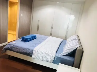 Modern bedroom with stylish decor and ensuite bathroom, featuring sleek built-in wardrobe and cozy bedding.
