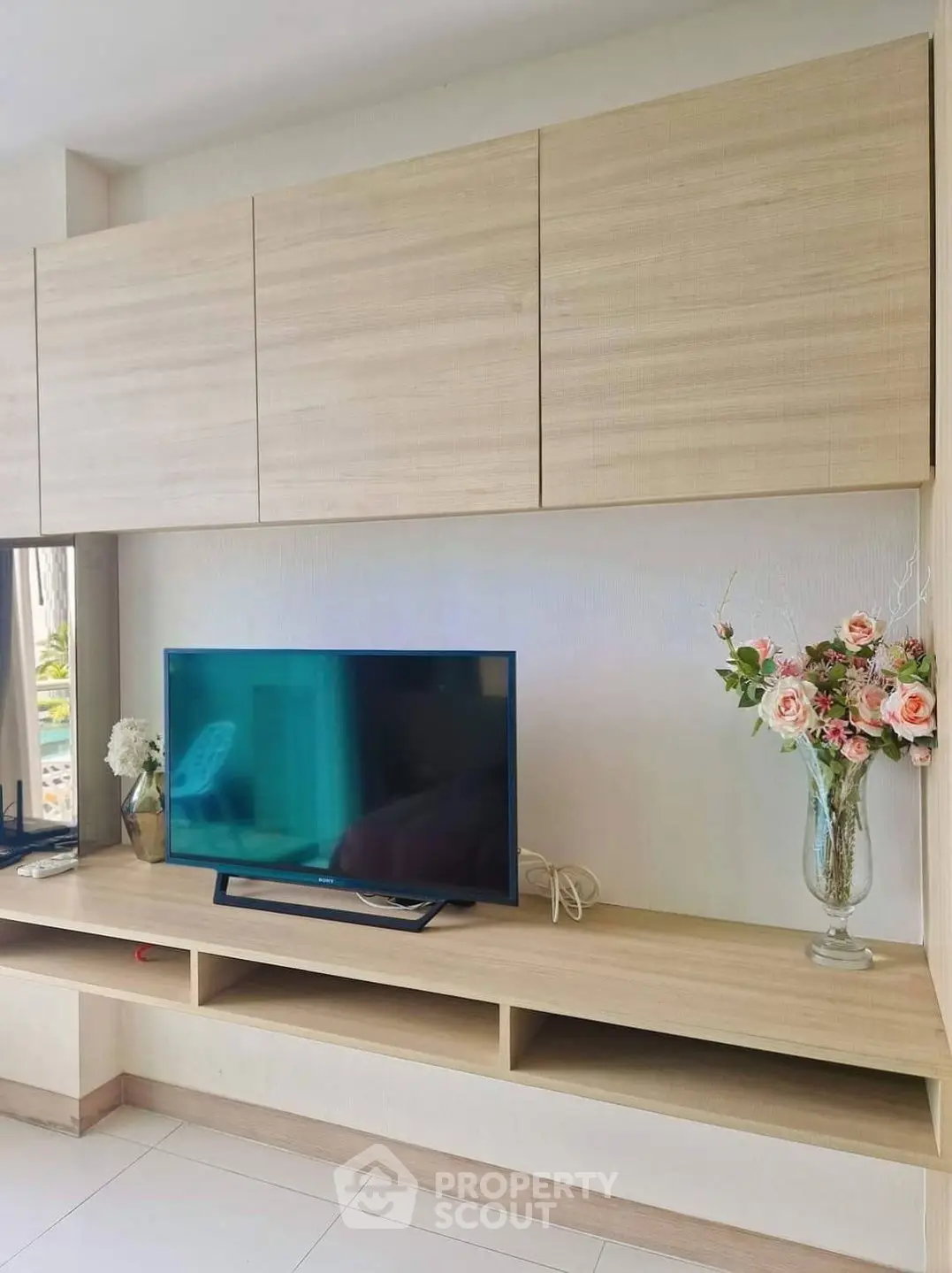 Modern living room with sleek wooden TV unit and elegant floral decor