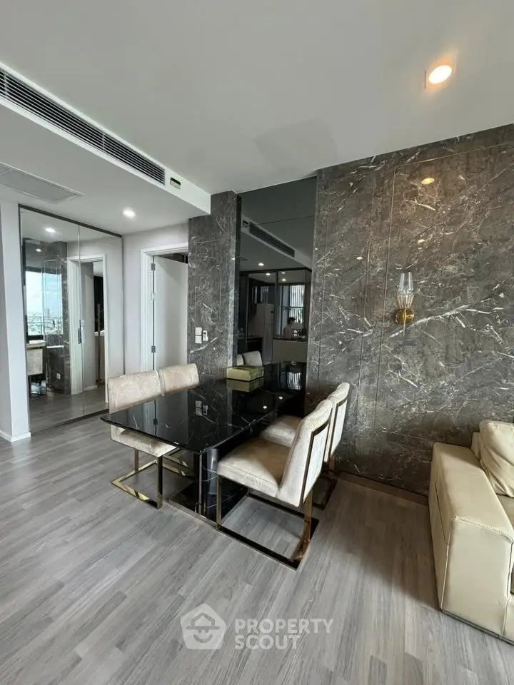 Modern dining area with marble accent wall and sleek furniture in luxury apartment.
