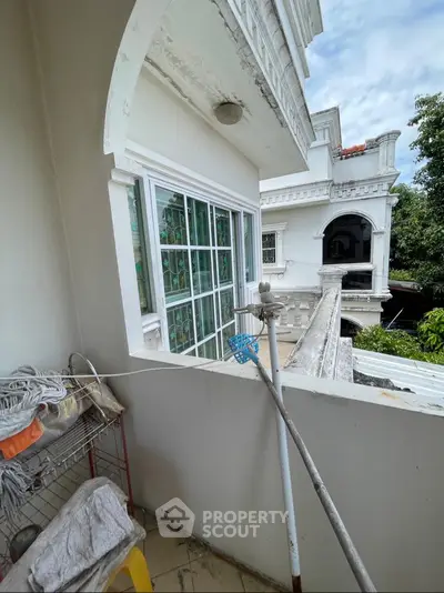 Charming balcony view of classic white building with intricate architectural details.