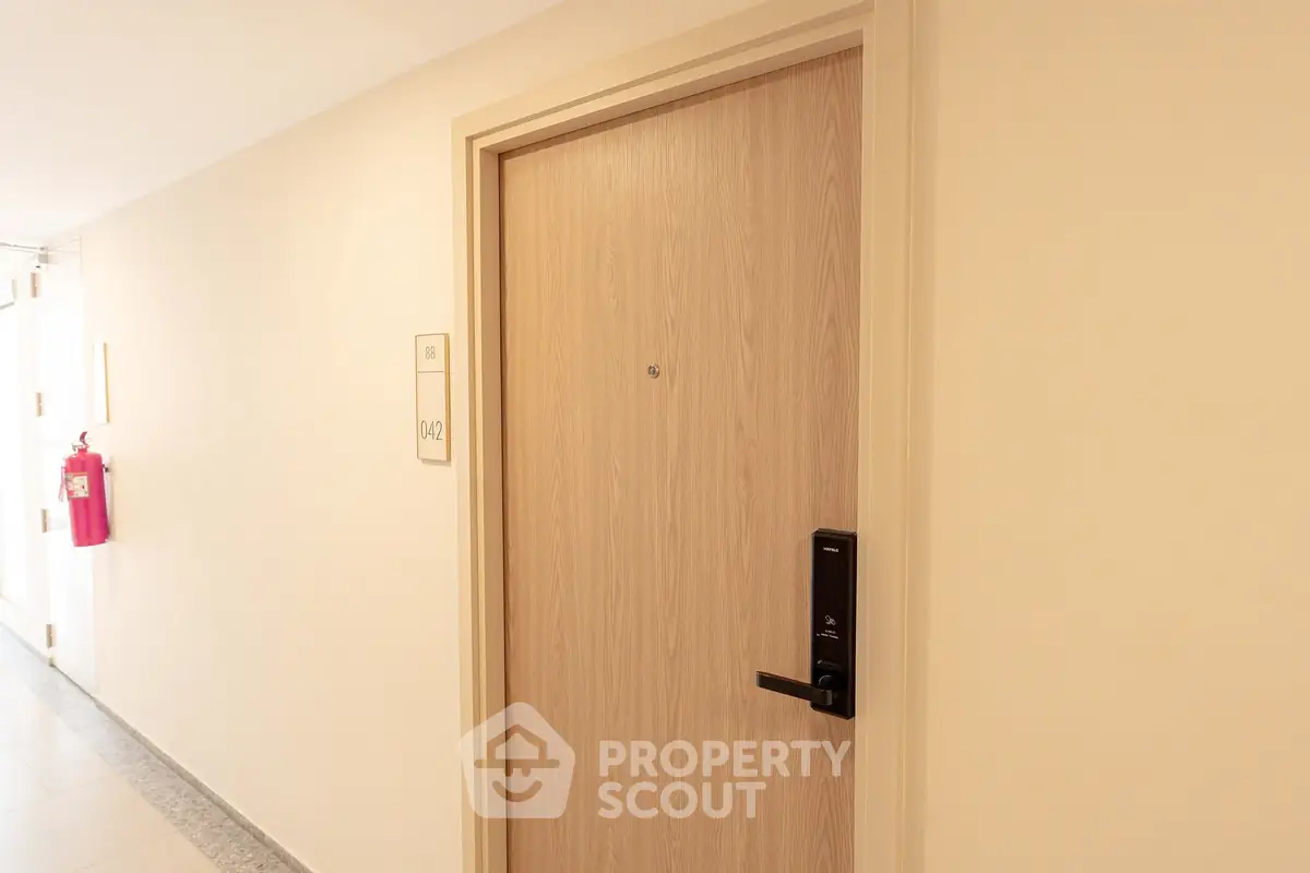 Modern apartment entrance with secure digital lock and clean hallway.