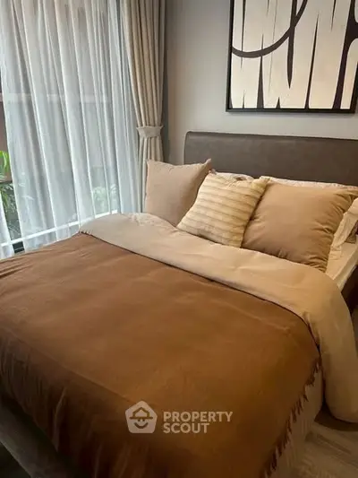 Cozy bedroom with elegant decor and large window for natural light.