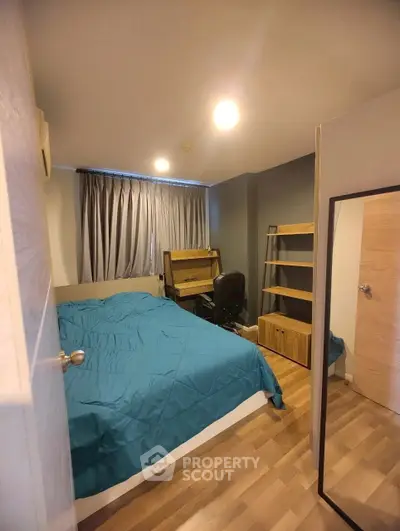 Cozy bedroom with wooden flooring and modern furnishings, ideal for urban living.
