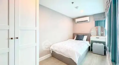 Cozy bedroom with modern decor, featuring a comfortable bed, air conditioning, and ample natural light.