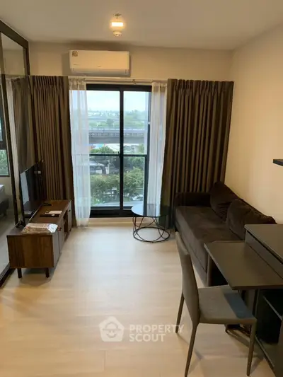 Modern living room with large window and stylish furniture in a high-rise apartment.