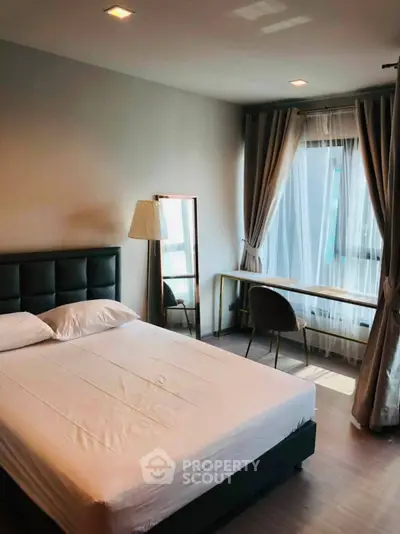 Modern bedroom with stylish decor and natural light, featuring a comfortable bed and elegant furnishings.