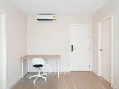 Minimalist study room with desk, chair, and air conditioning in modern apartment.