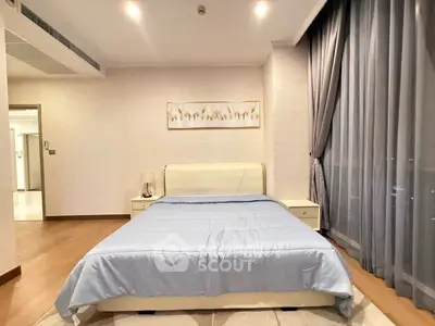 Spacious bedroom with elegant decor and large window for natural light.