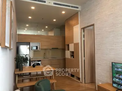 Modern open-layout kitchen with wooden cabinetry and integrated appliances in a cozy apartment.