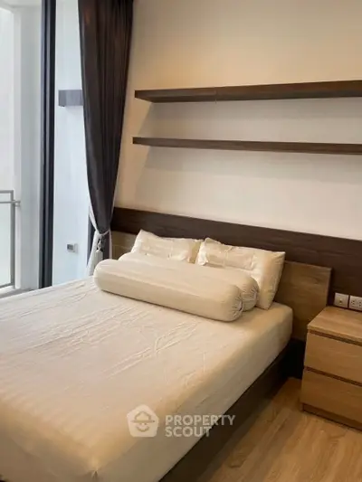 Modern bedroom with sleek wooden shelves and large window for natural light.