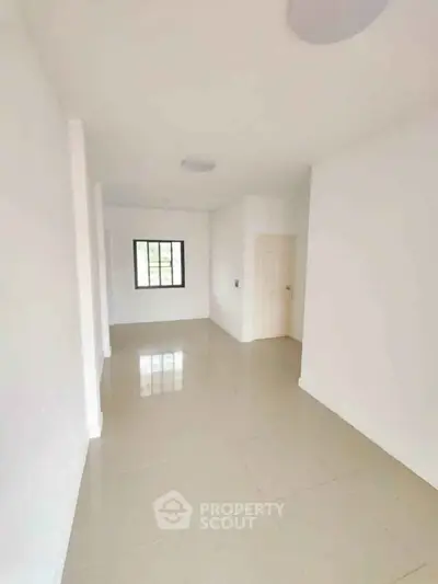 Spacious minimalist room with glossy tiled floor and bright natural light.