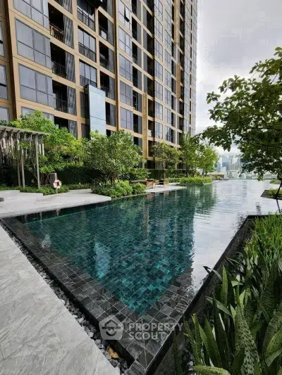 Luxurious high-rise building with stunning pool and lush greenery, offering a serene urban oasis.