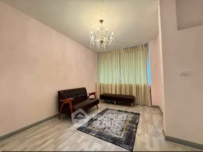 Elegant living room with chandelier and stylish furniture, perfect for modern living.