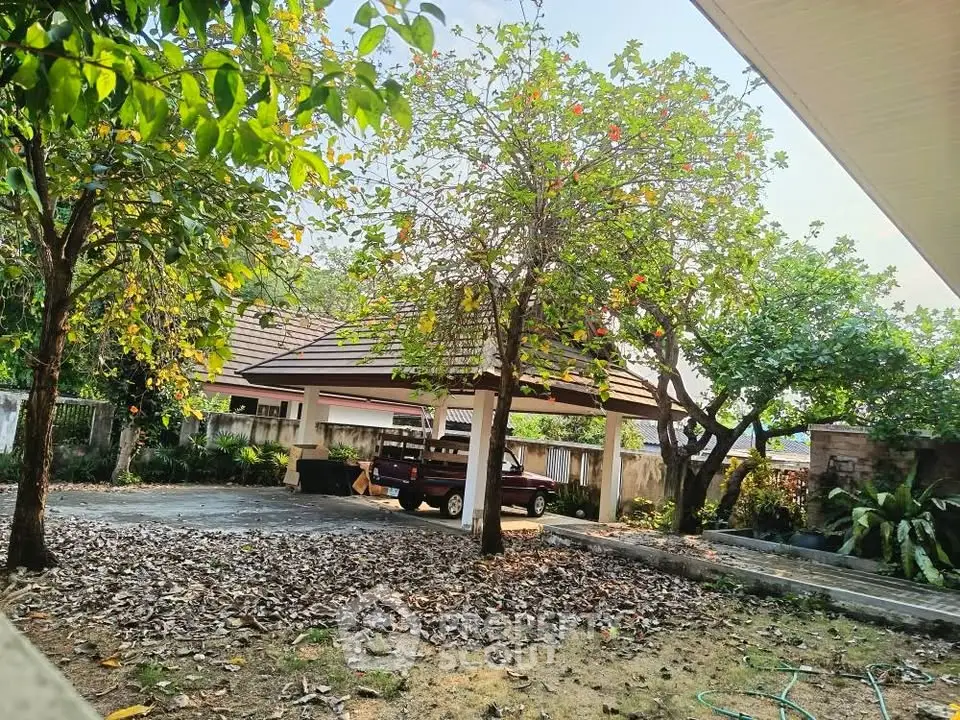 Charming garden view with carport and lush greenery in a serene residential setting.