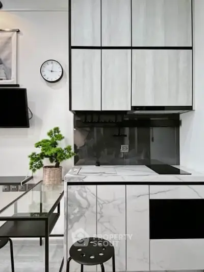 Modern kitchen with sleek cabinetry and marble countertops, featuring a minimalist design and stylish decor.