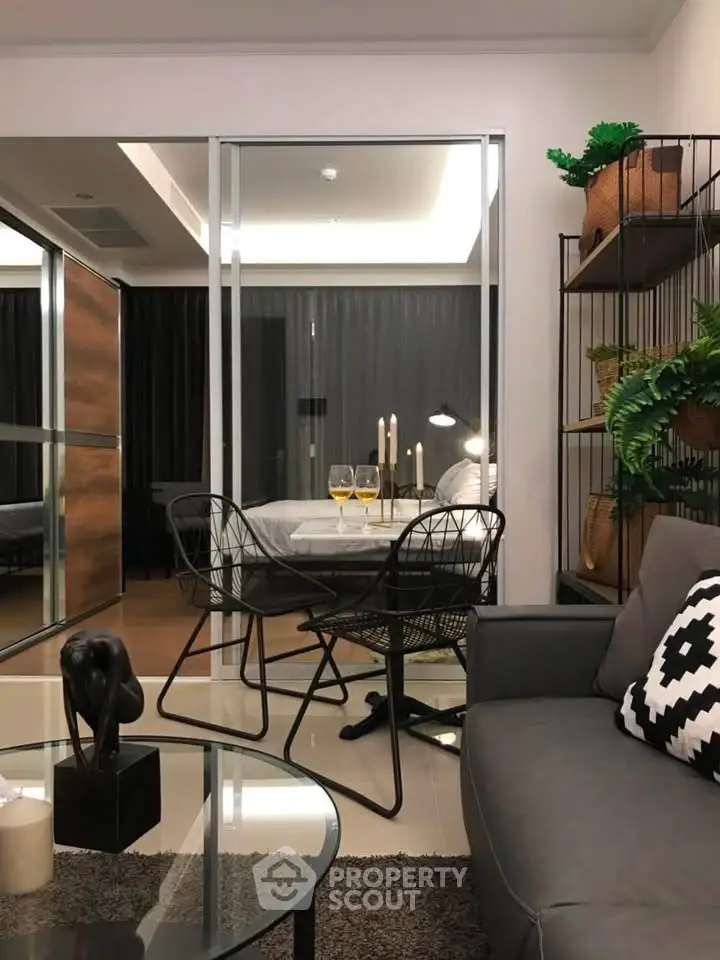 Modern living room with glass partition, stylish decor, and cozy ambiance in a contemporary apartment.