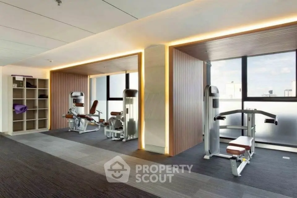 Modern gym with state-of-the-art equipment and sleek design in luxury apartment building.