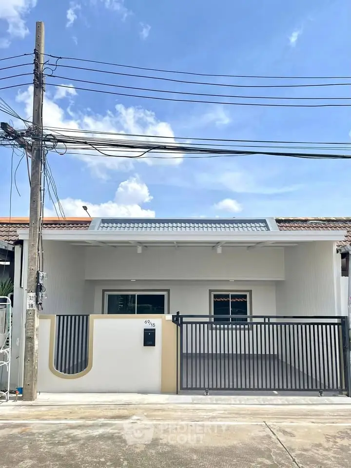 Charming single-story home with modern facade and gated driveway in a serene neighborhood.
