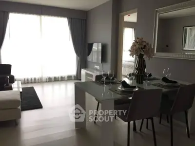 Modern living room with dining area, large windows, and stylish decor