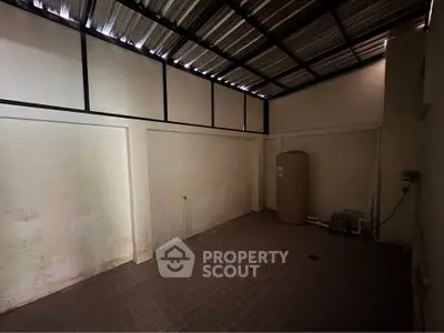 Spacious storage room with high ceiling and industrial design, perfect for versatile use in any property.