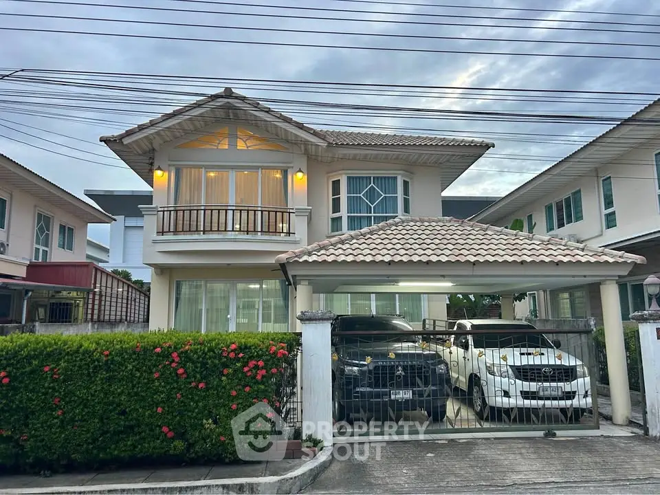 Charming two-story house with a tiled roof and spacious driveway in a serene neighborhood.