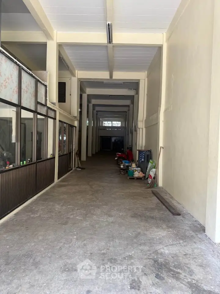 Spacious industrial-style corridor with high ceilings and ample storage potential.