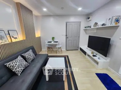 Modern living room with sleek furniture and stylish decor, featuring a comfortable sofa and large TV.