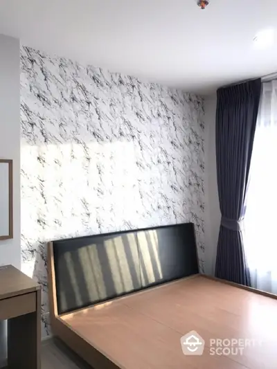 Modern bedroom with marble accent wall and natural light