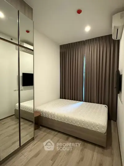 Modern bedroom with mirrored wardrobe and minimalist decor
