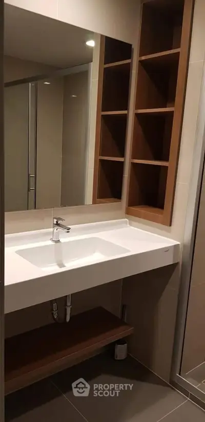 Modern bathroom with sleek sink and wooden shelving, perfect for contemporary living.