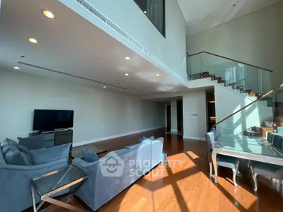 Spacious modern living room with high ceilings and elegant staircase