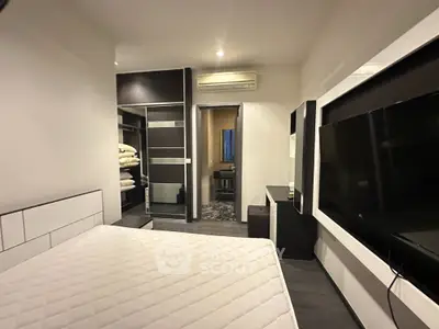 Sleek modern bedroom with large bed, built-in wardrobe, and wall-mounted TV, offering a cozy and stylish living space.