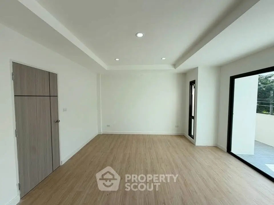 Spacious modern living room with large windows and wooden flooring