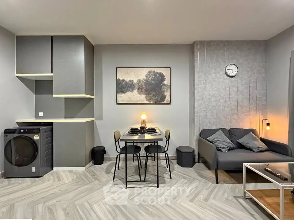 Modern living room with stylish decor and dining area, featuring a washing machine and contemporary furniture.