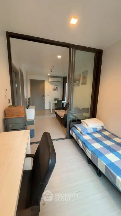 Modern studio apartment with sliding glass partition and cozy furnishings