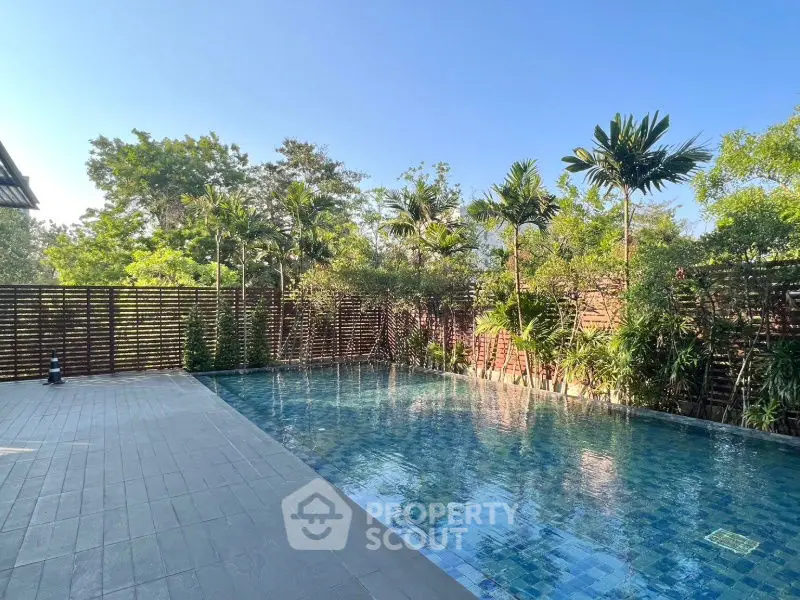 Luxurious outdoor pool with lush greenery and serene ambiance, perfect for relaxation and leisure.