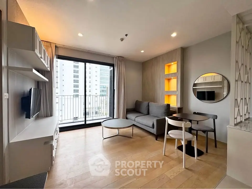 Modern living room with balcony view, featuring stylish furniture and natural light.