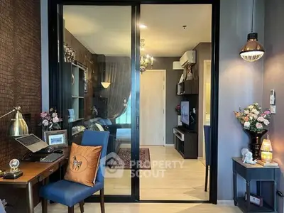 Modern living room with stylish decor and sliding glass doors leading to a cozy bedroom.